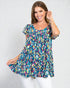 Woman wearing a colorful patterned dress against a white background