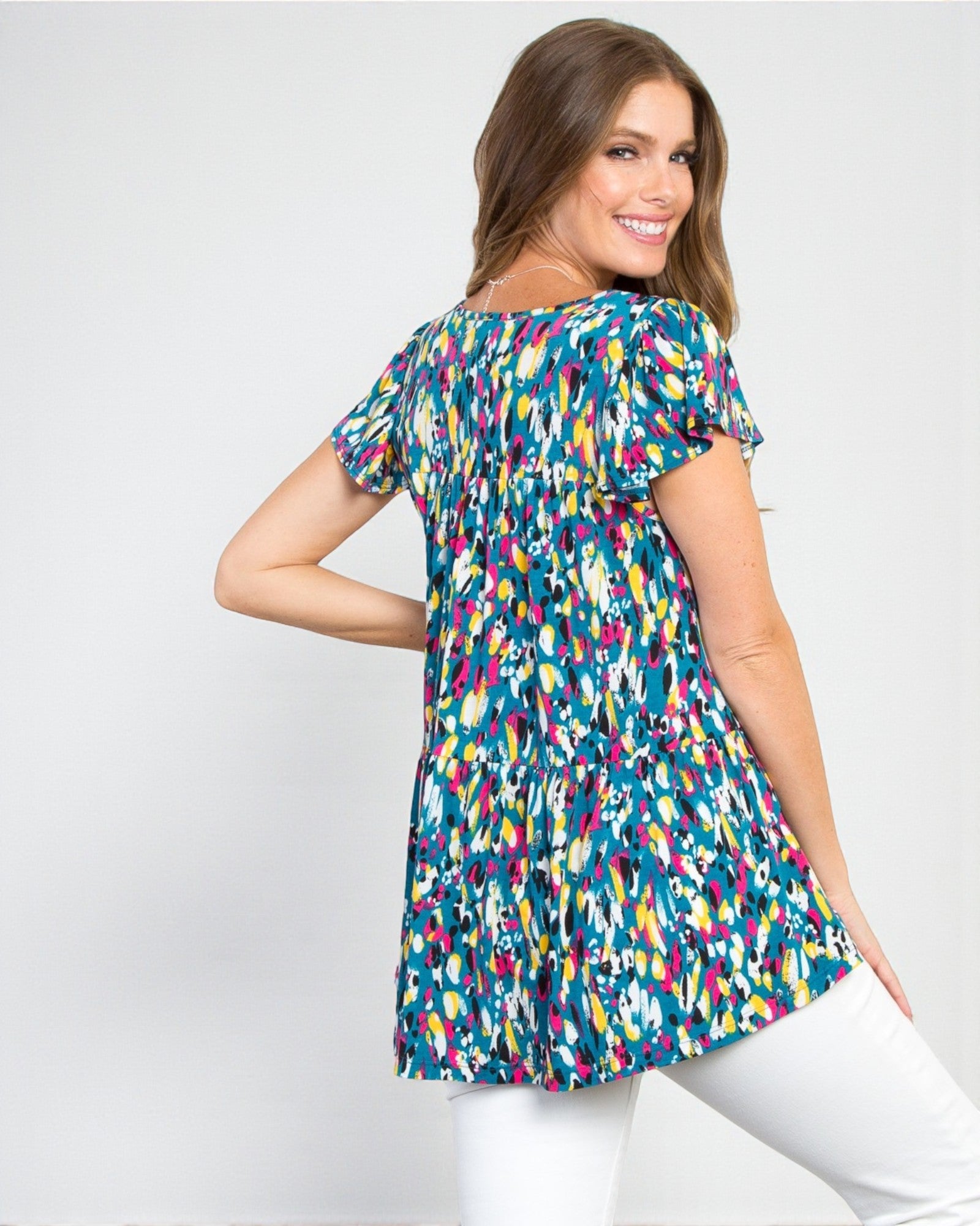 Woman wearing a colorful patterned top on a white background