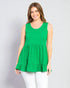 Woman wearing a green sleeveless top with a plain background