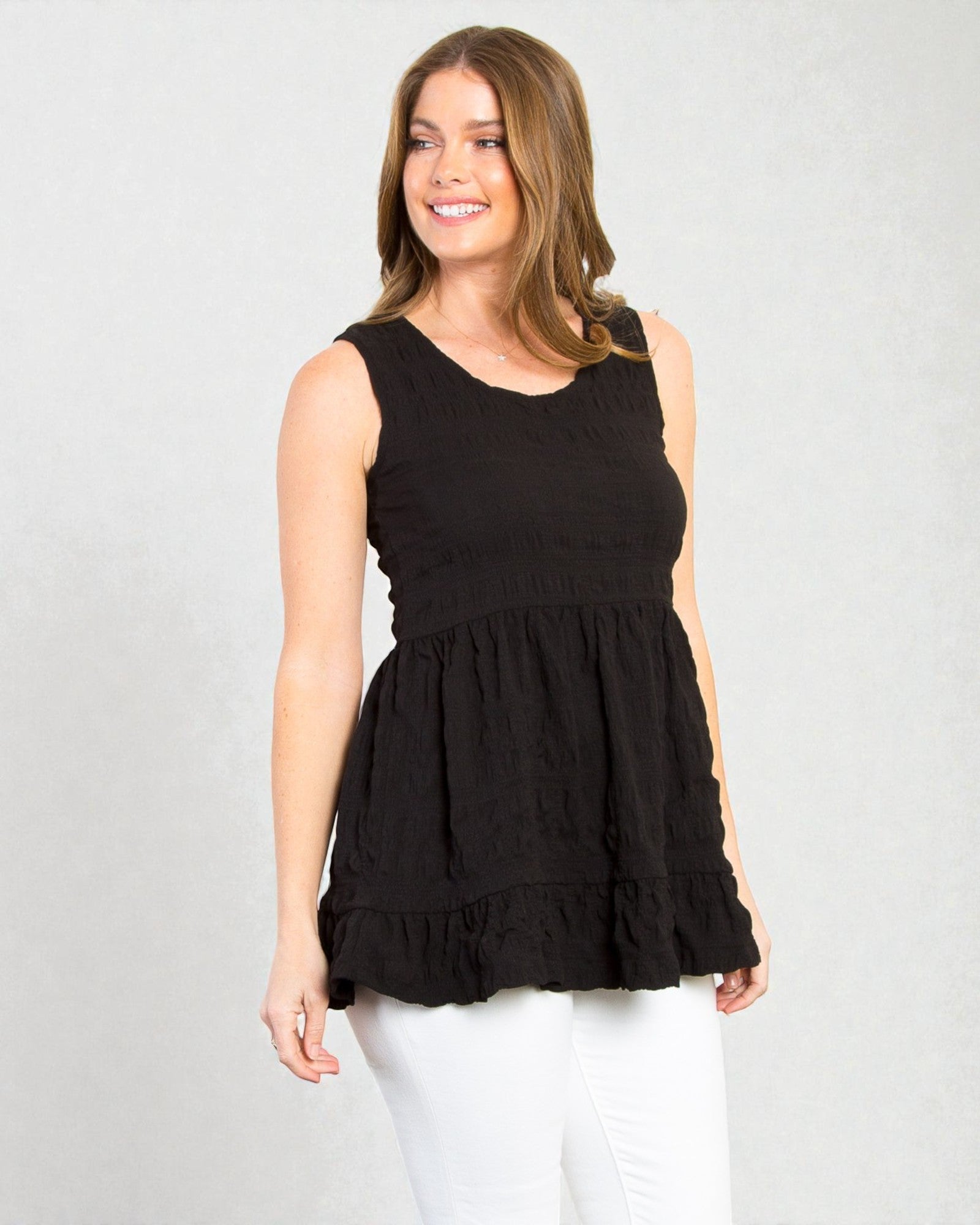 Woman wearing a black sleeveless top with a white background