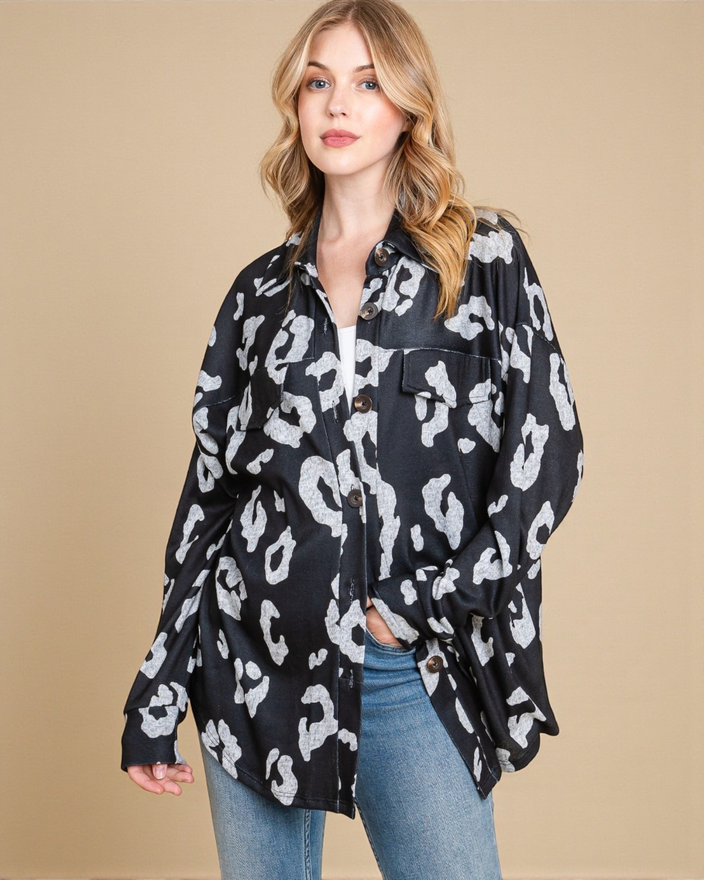Woman wearing a black and white leopard print shirt against a beige background