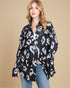 Woman wearing a black and white leopard print shirt against a beige background