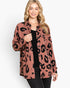 A woman modeling a long-sleeve button-up shirt jacket with a dusty rose and black leopard print pattern, worn open over a black top and dark jeans against a plain white background.