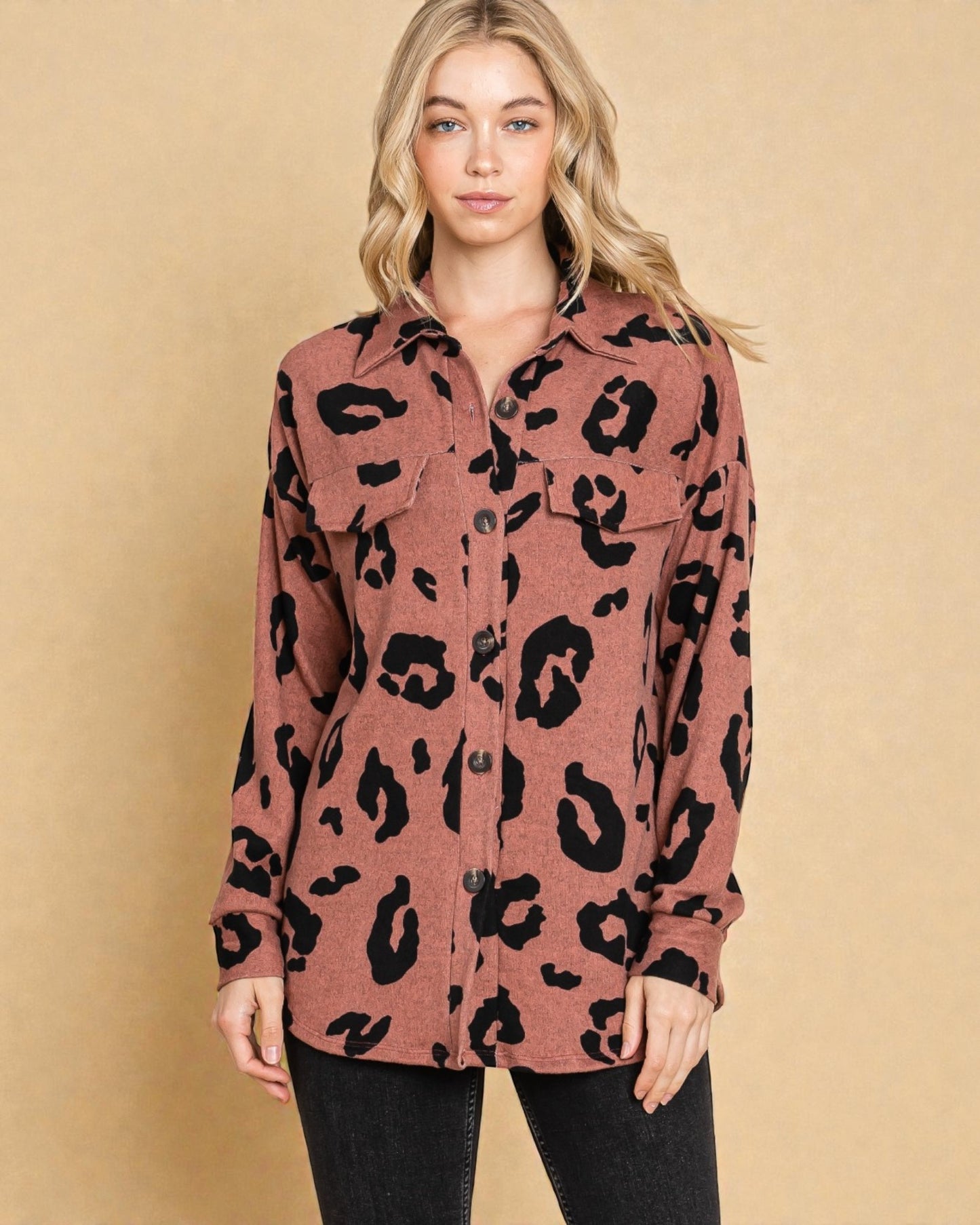 Woman wearing a leopard print shirt against a beige background