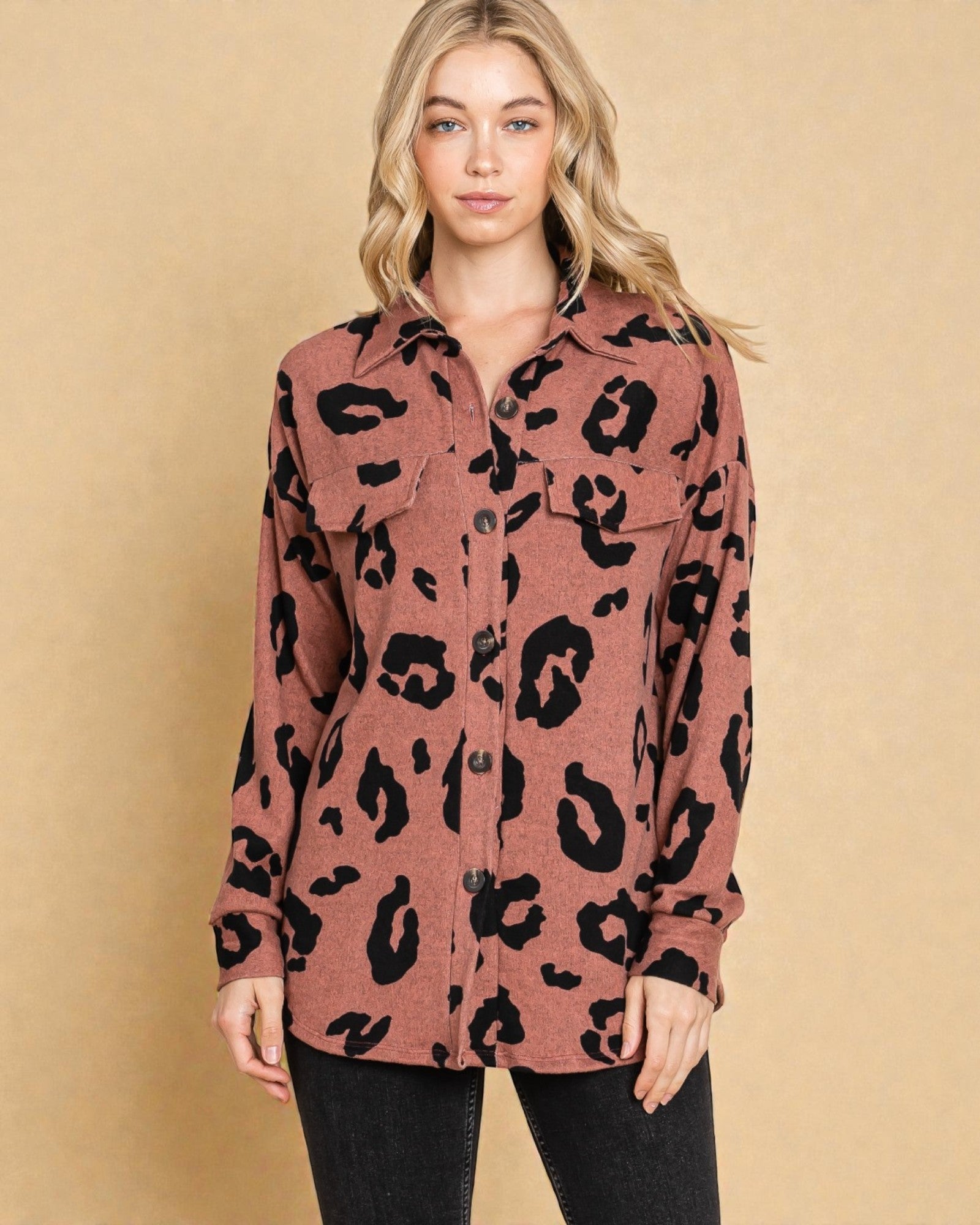 Woman wearing a leopard print shirt against a beige background