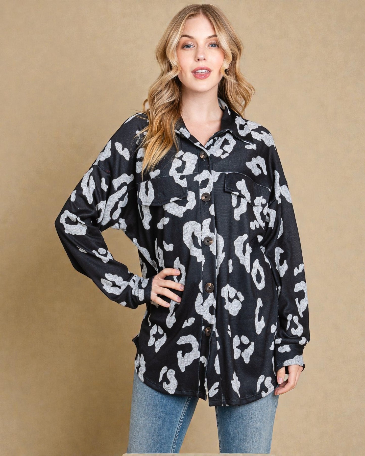 Woman wearing a black and white leopard print shirt against a beige background