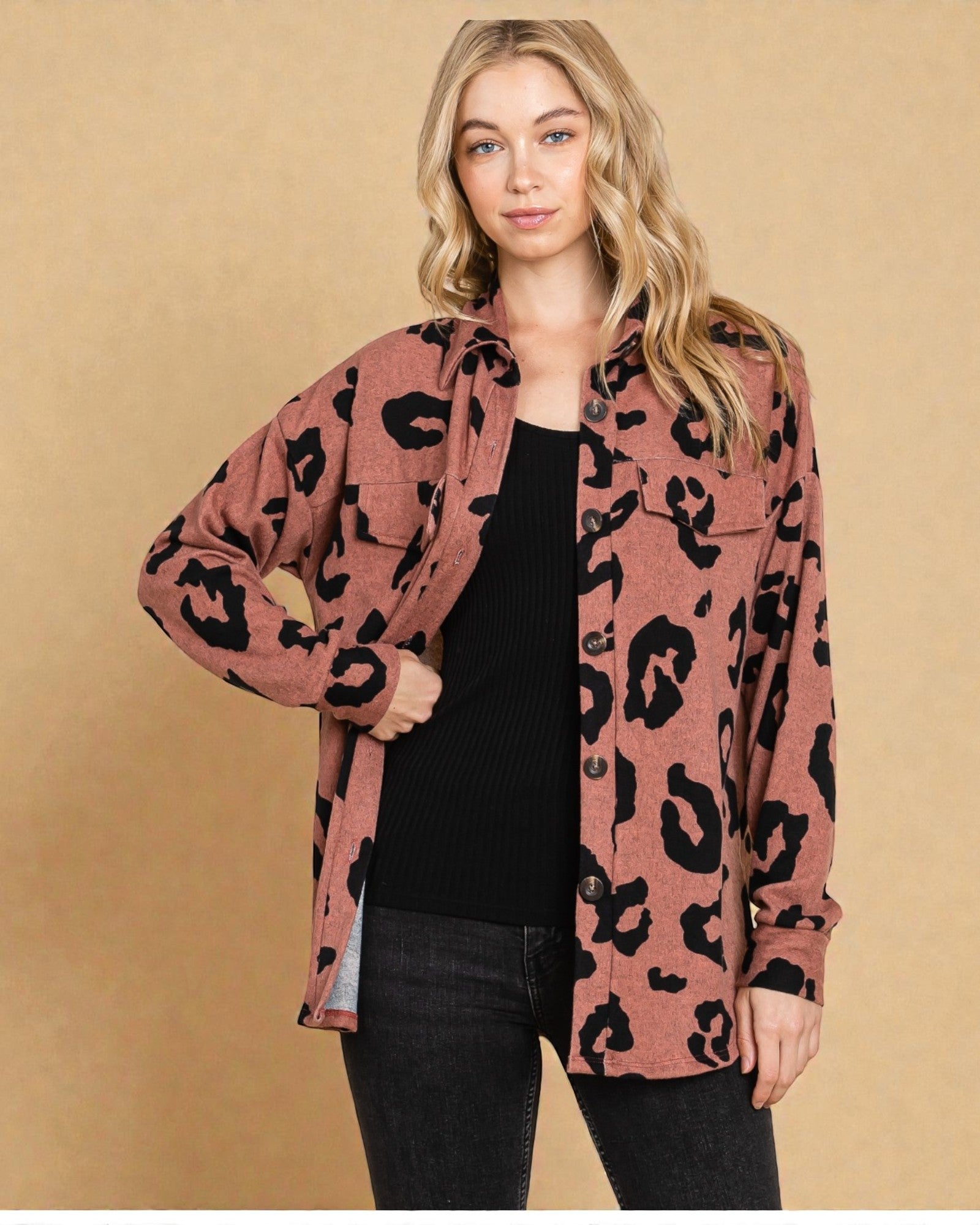Woman wearing a pink leopard print cardigan against a beige background