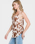 Woman wearing a cow print tank top and jeans on a white background