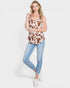 Woman wearing a cow print top and light blue jeans on a white background