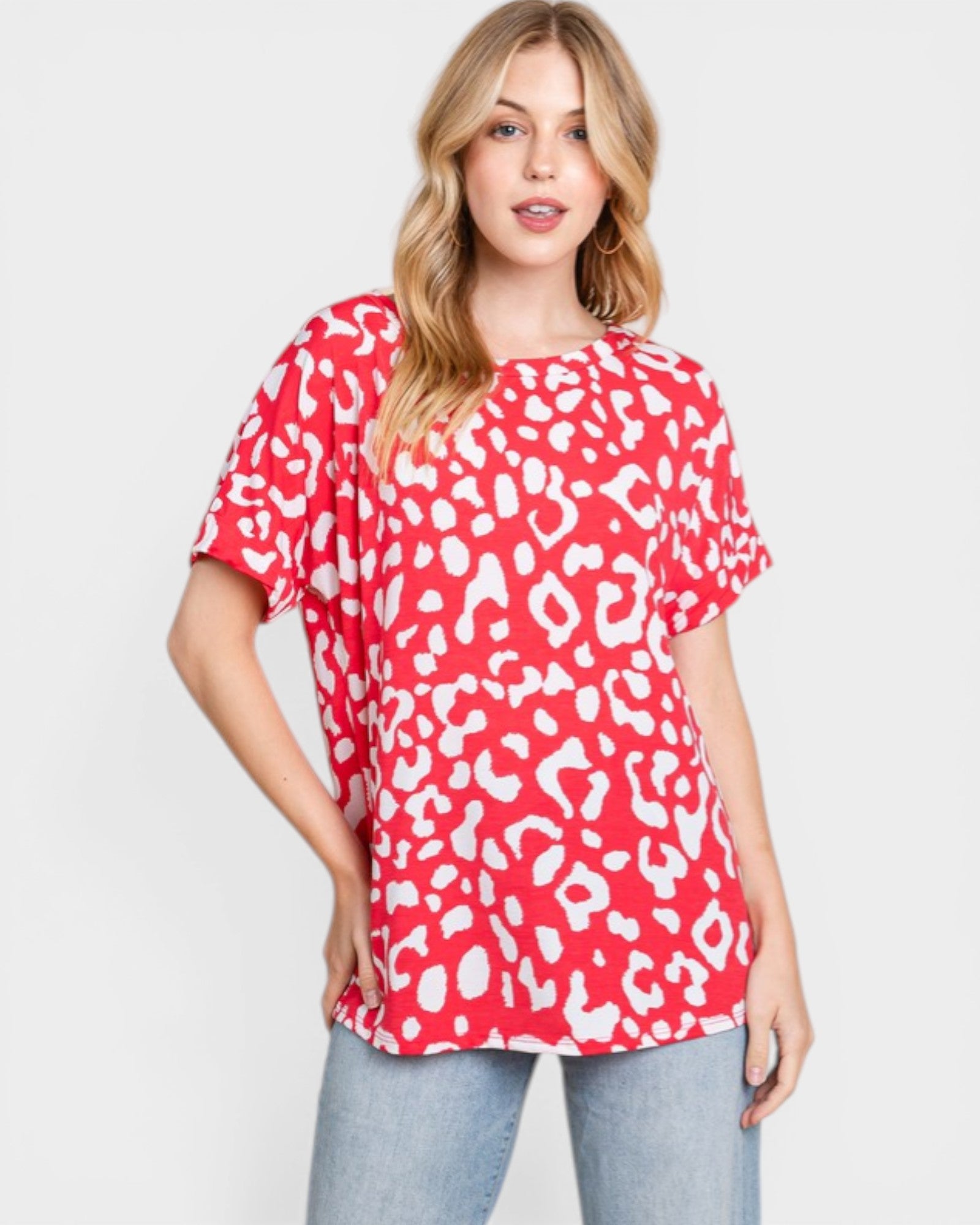 Woman wearing a red leopard print top against a white background