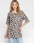 Woman wearing a leopard print top on a white background