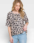 Woman wearing a leopard print top and light blue jeans on a white background