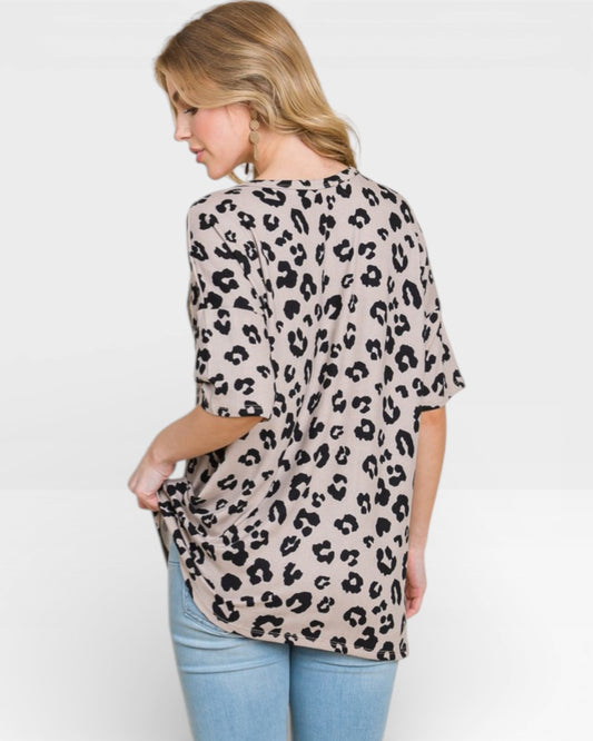 Woman wearing a leopard print top on a white background