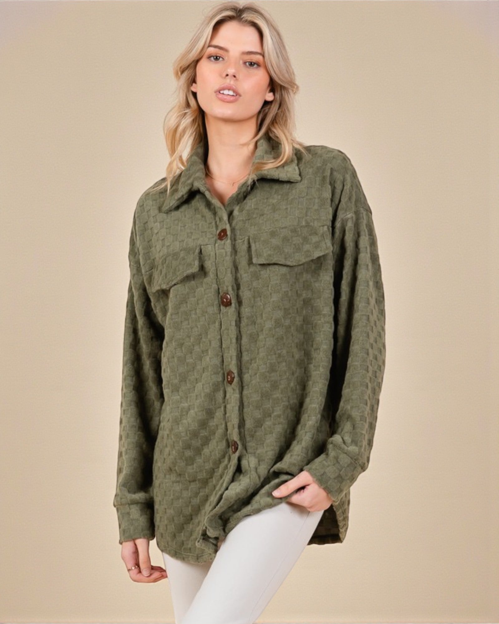 Woman wearing a green button-up shirt against a beige background
