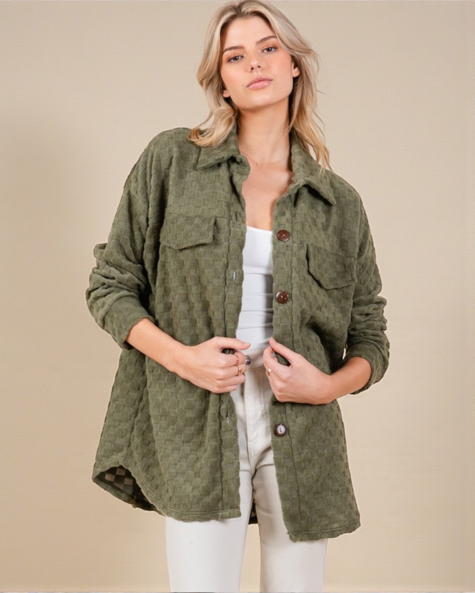 Woman wearing a green jacket on a beige background