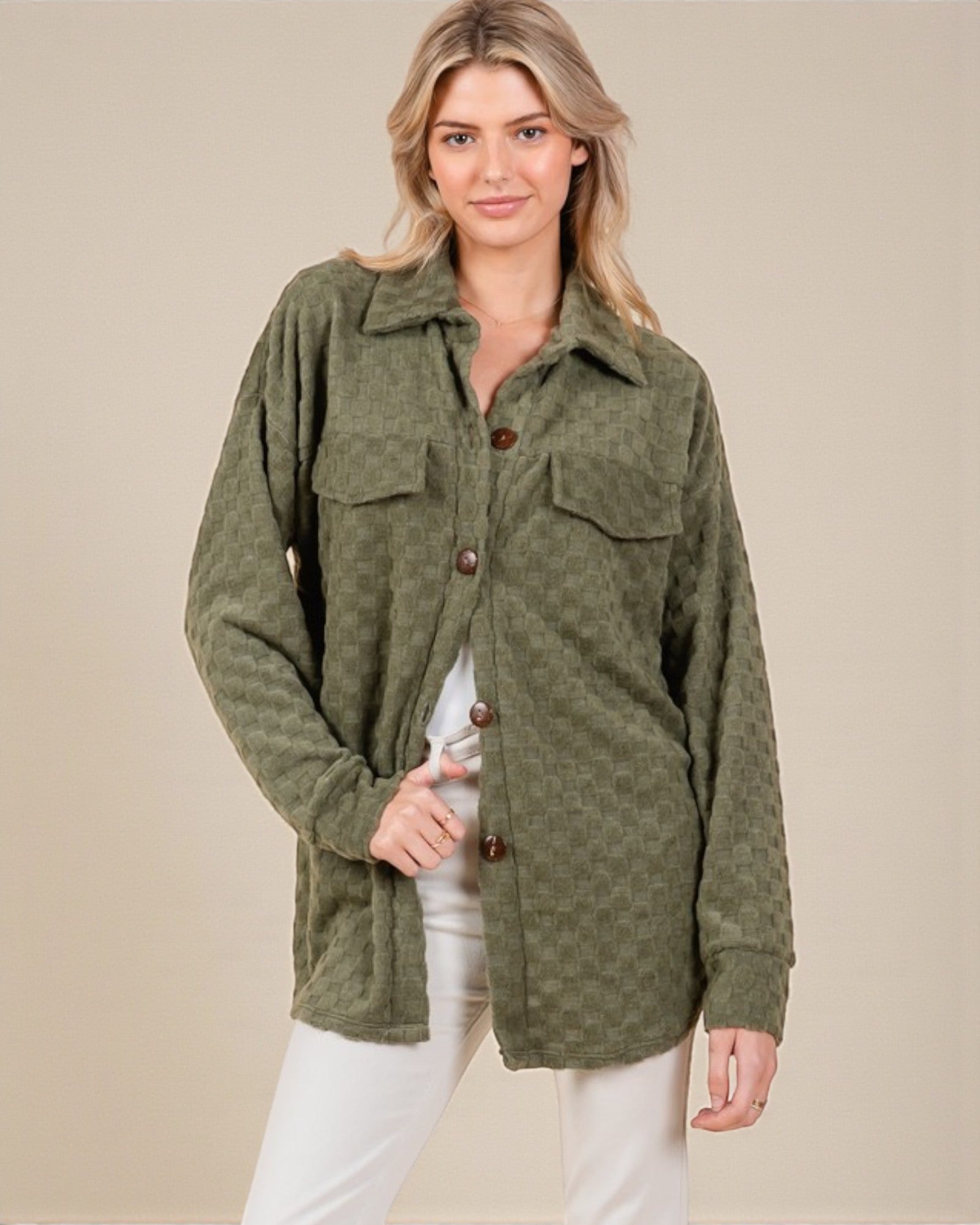 Woman wearing a green jacket with button details on a beige background