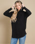 Woman wearing a black hoodie and blue jeans against a beige background