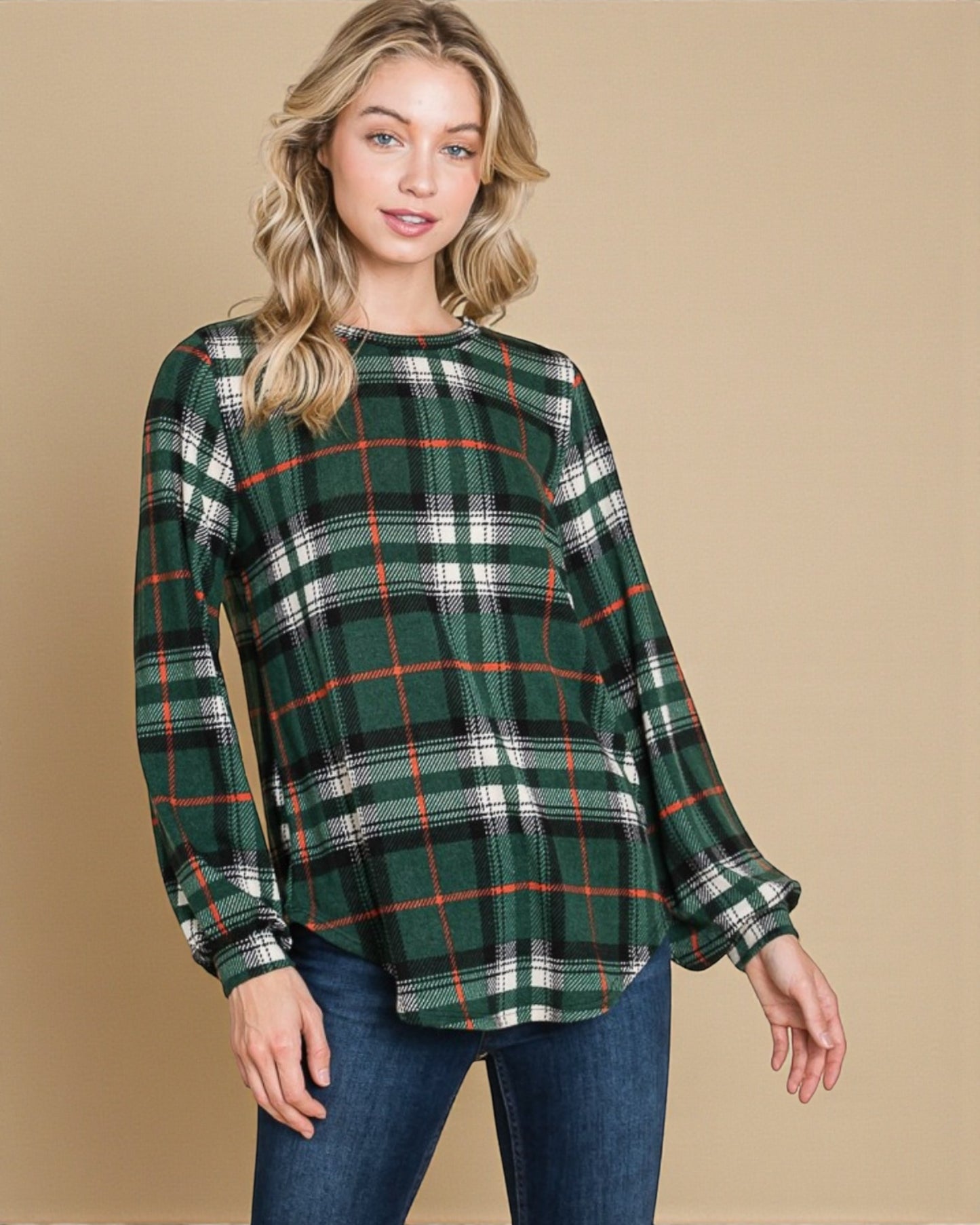 Woman wearing a green plaid shirt against a beige background