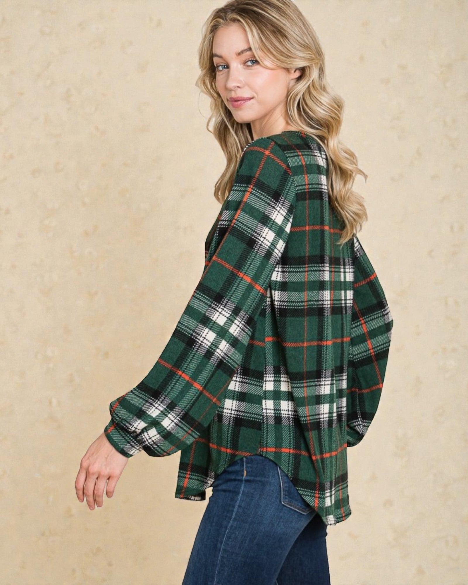 Woman wearing a green plaid shirt against a beige background
