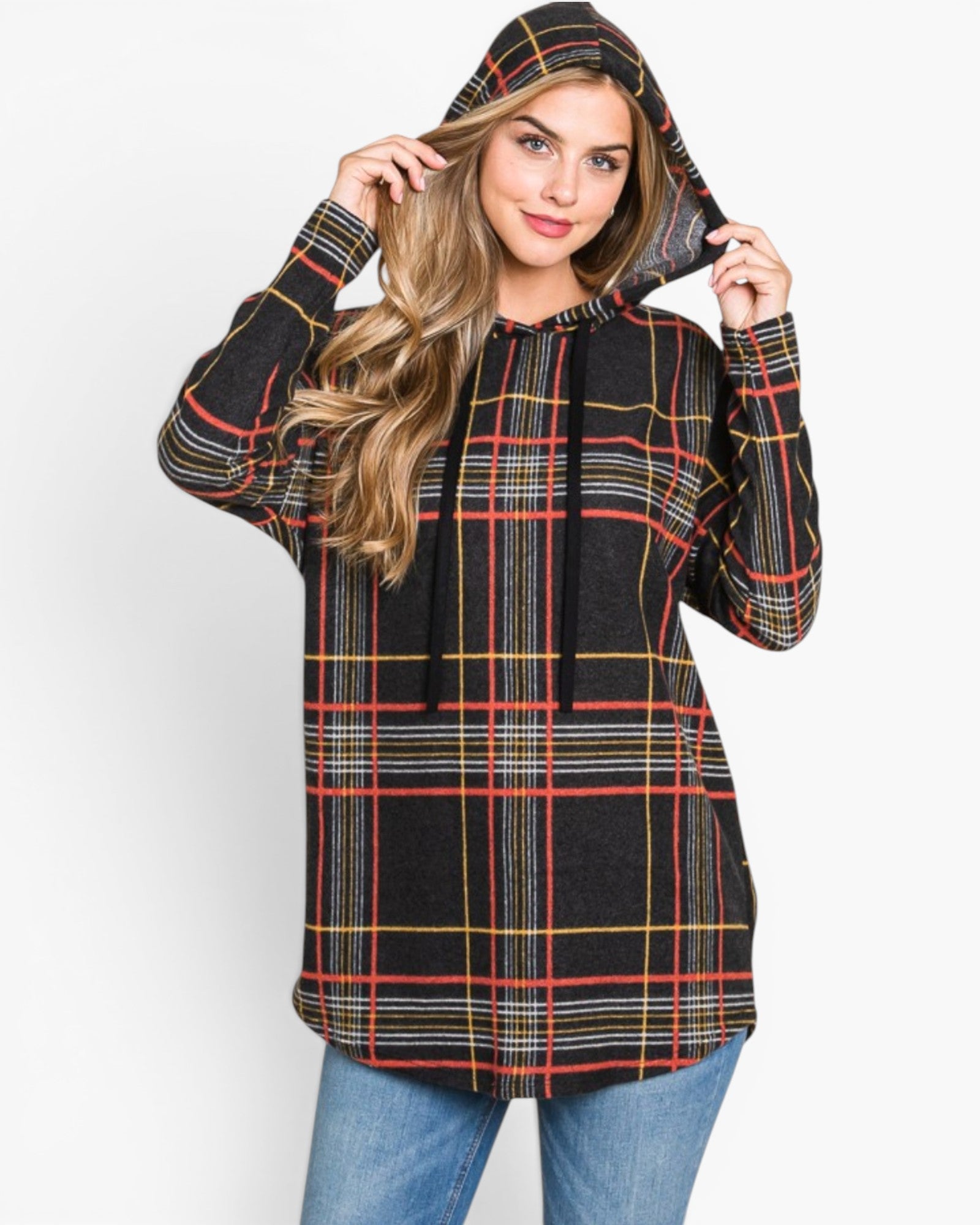 A woman wearing a black hooded pullover sweatshirt with a red, yellow, and white plaid pattern, paired with blue jeans, against a plain white background.