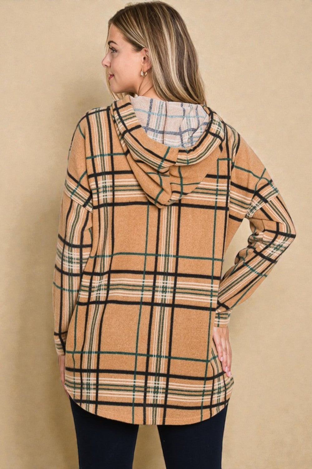 Woman wearing a plaid hoodie against a beige background
