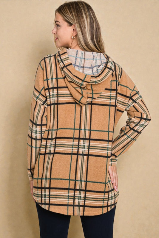 Woman wearing a plaid hoodie against a beige background
