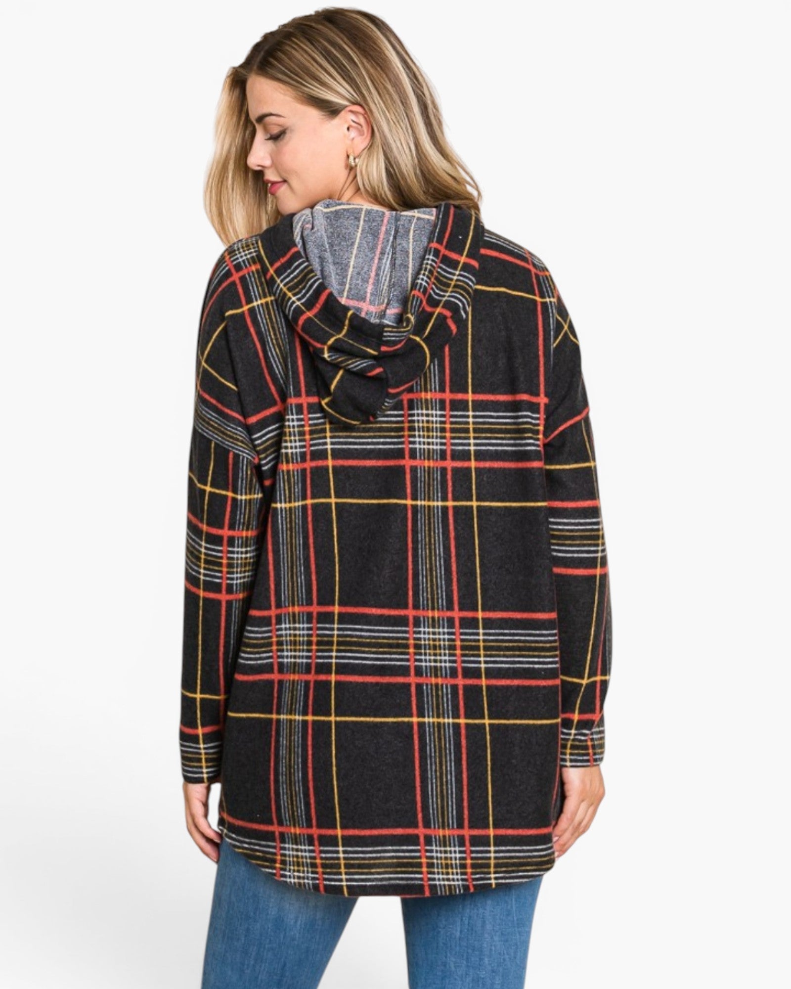 A woman wearing a black hooded pullover sweater with a red, yellow, and white plaid pattern, paired with blue jeans, shown from a three-quarters back view against a light gray background.