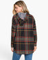 A woman wearing a black hooded pullover sweater with a red, yellow, and white plaid pattern, paired with blue jeans, shown from a three-quarters back view against a light gray background.