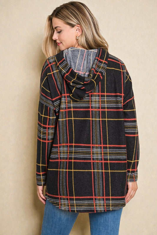 Woman wearing a plaid coat against a beige background