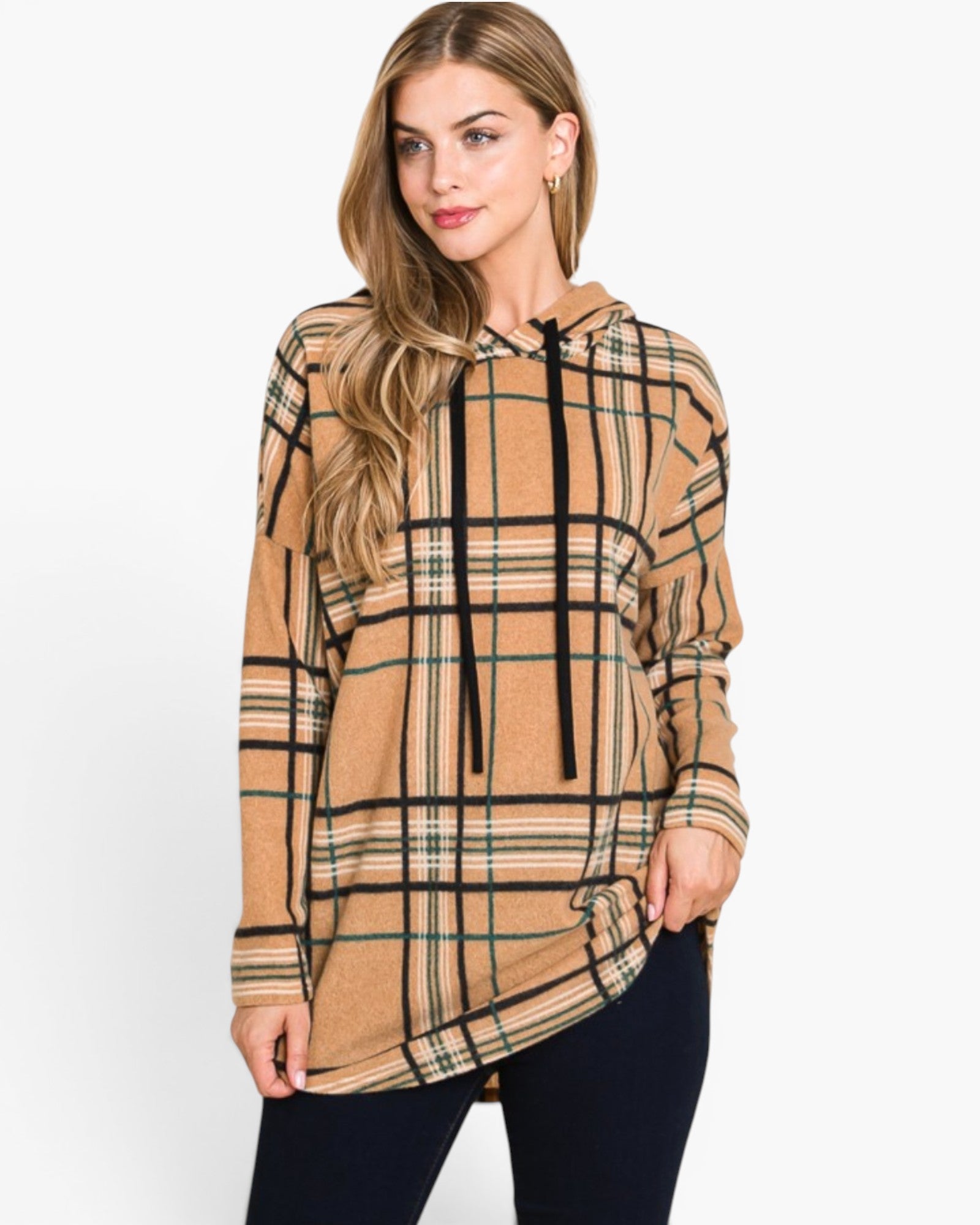 A woman wearing a beige plaid hoodie with black drawstrings and black pants, photographed against a plain white studio background.