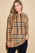 Woman wearing a beige plaid hoodie against a beige background