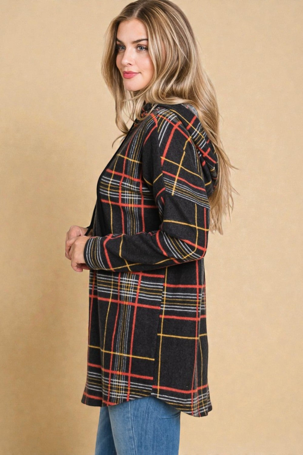 Woman wearing a plaid shirt against a beige background