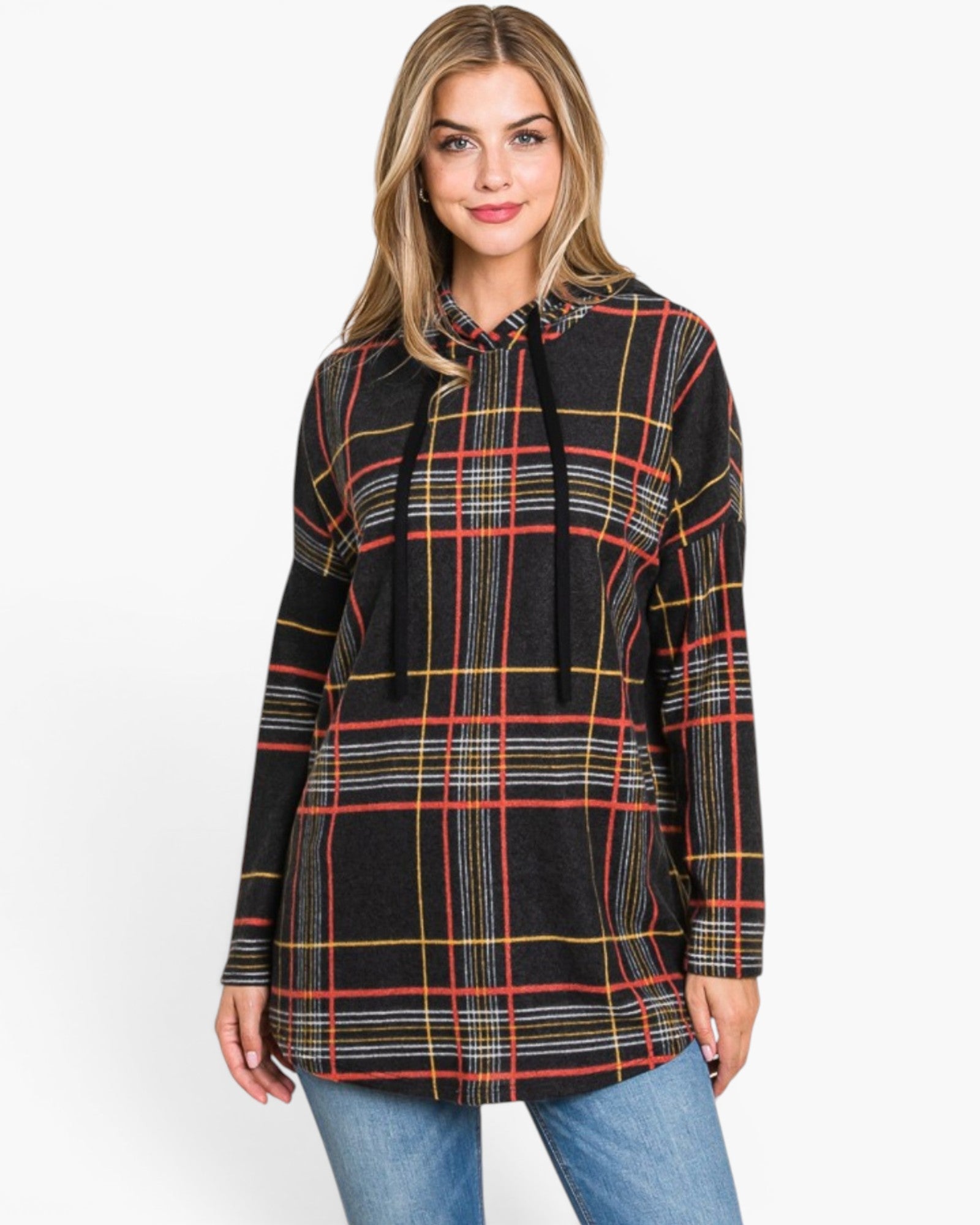 A woman wearing a black long-sleeve hooded tunic top with a red, yellow, and white plaid pattern, paired with blue jeans, against a plain white background.