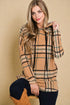 Woman wearing a plaid hoodie with a beige background