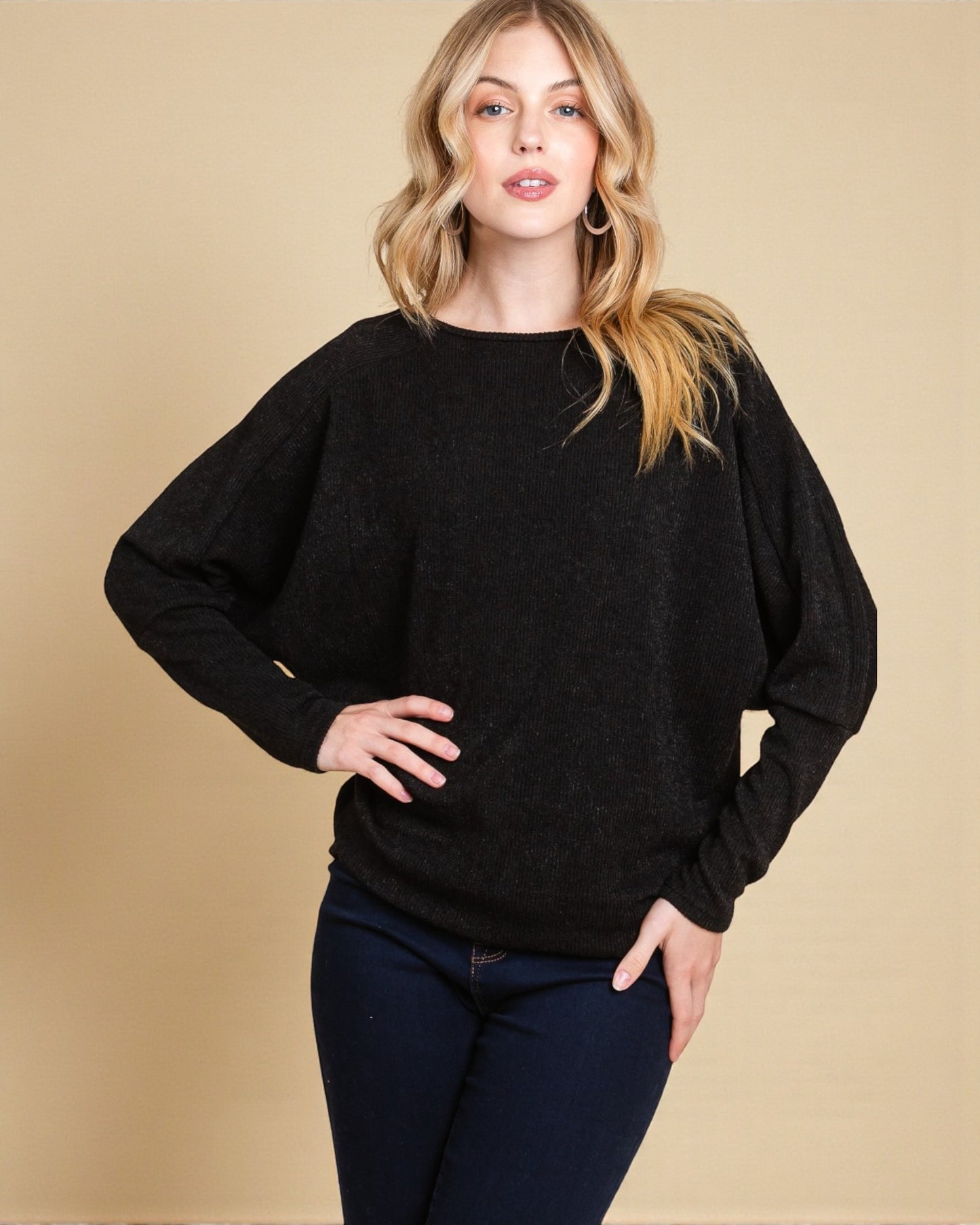 Woman wearing a black sweater against a beige background
