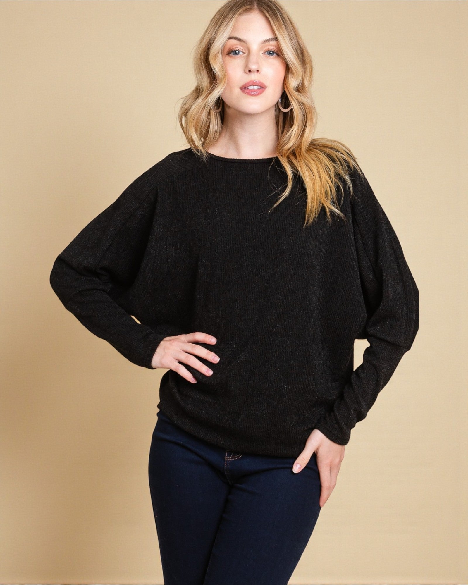 Woman wearing a black sweater against a beige background