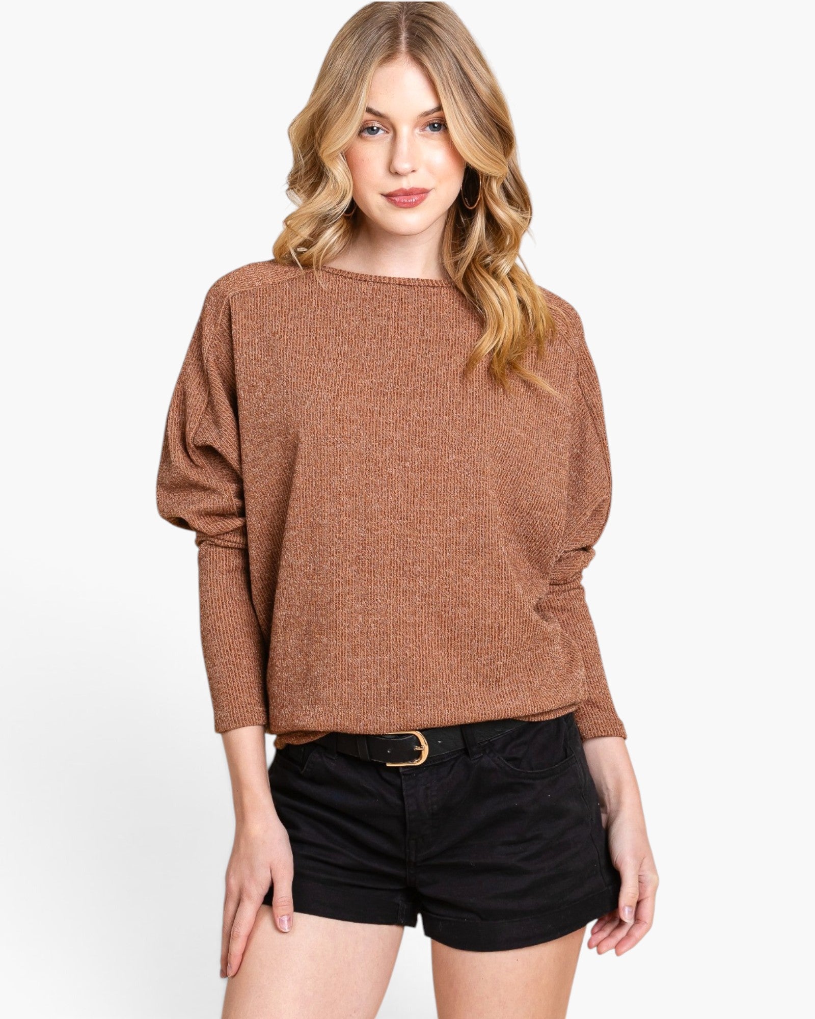 A woman modeling a brown knit sweater with balloon sleeves and black shorts against a plain white background.