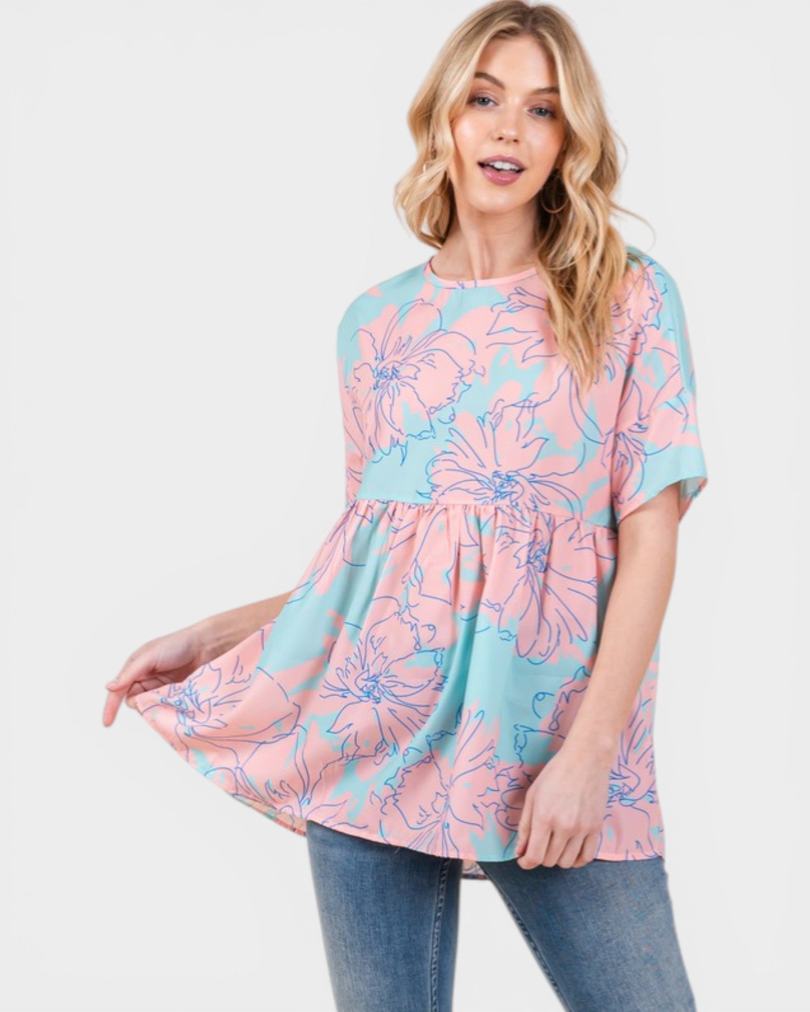 Woman wearing a pink and blue floral patterned top on a white background