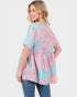 Woman wearing a pink and blue floral blouse with a white background