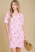 Woman wearing a pink floral dress against a beige background