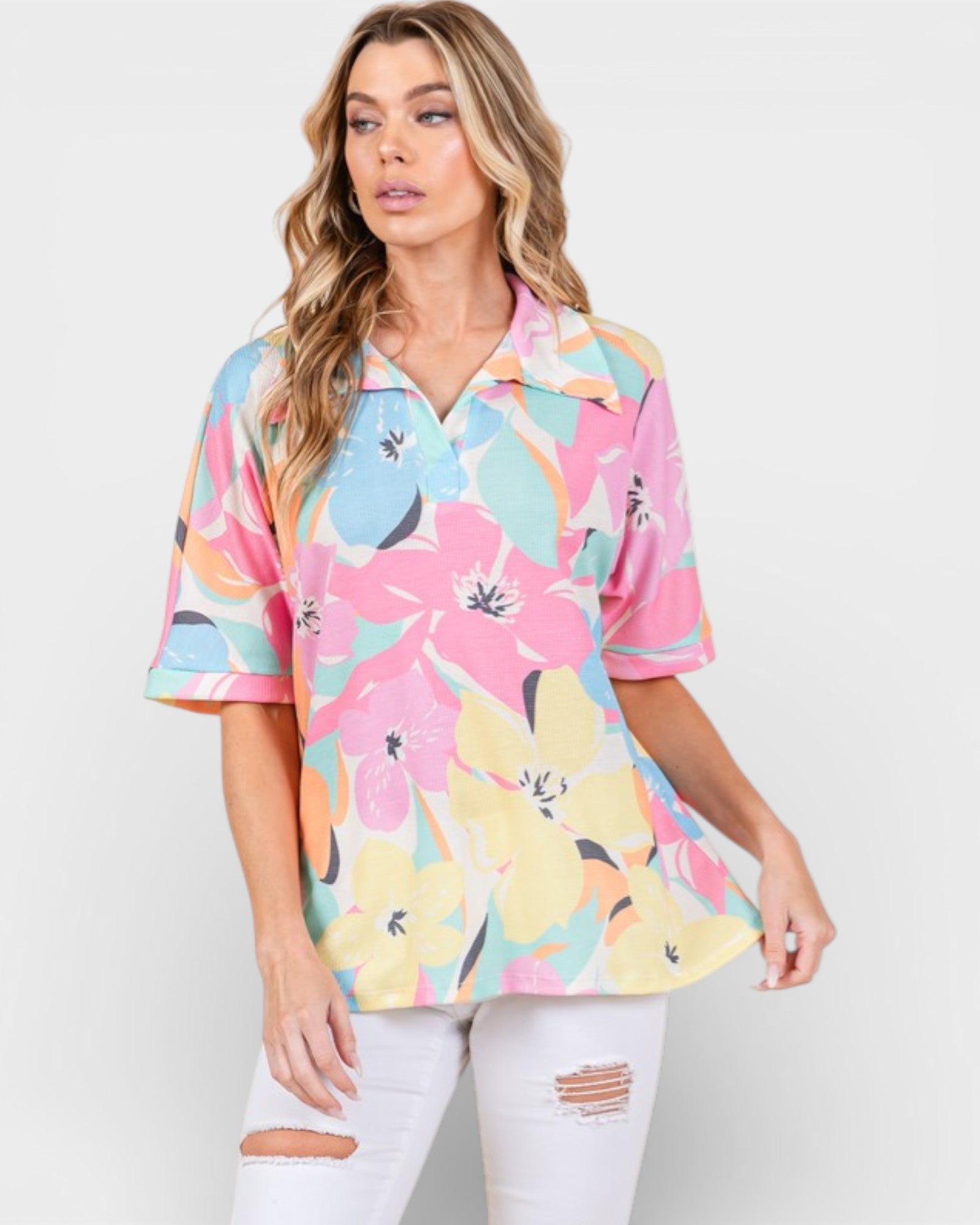 Woman wearing a colorful floral blouse against a white background