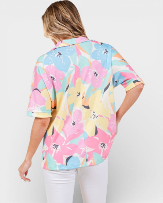 Woman wearing a colorful floral shirt on a white background