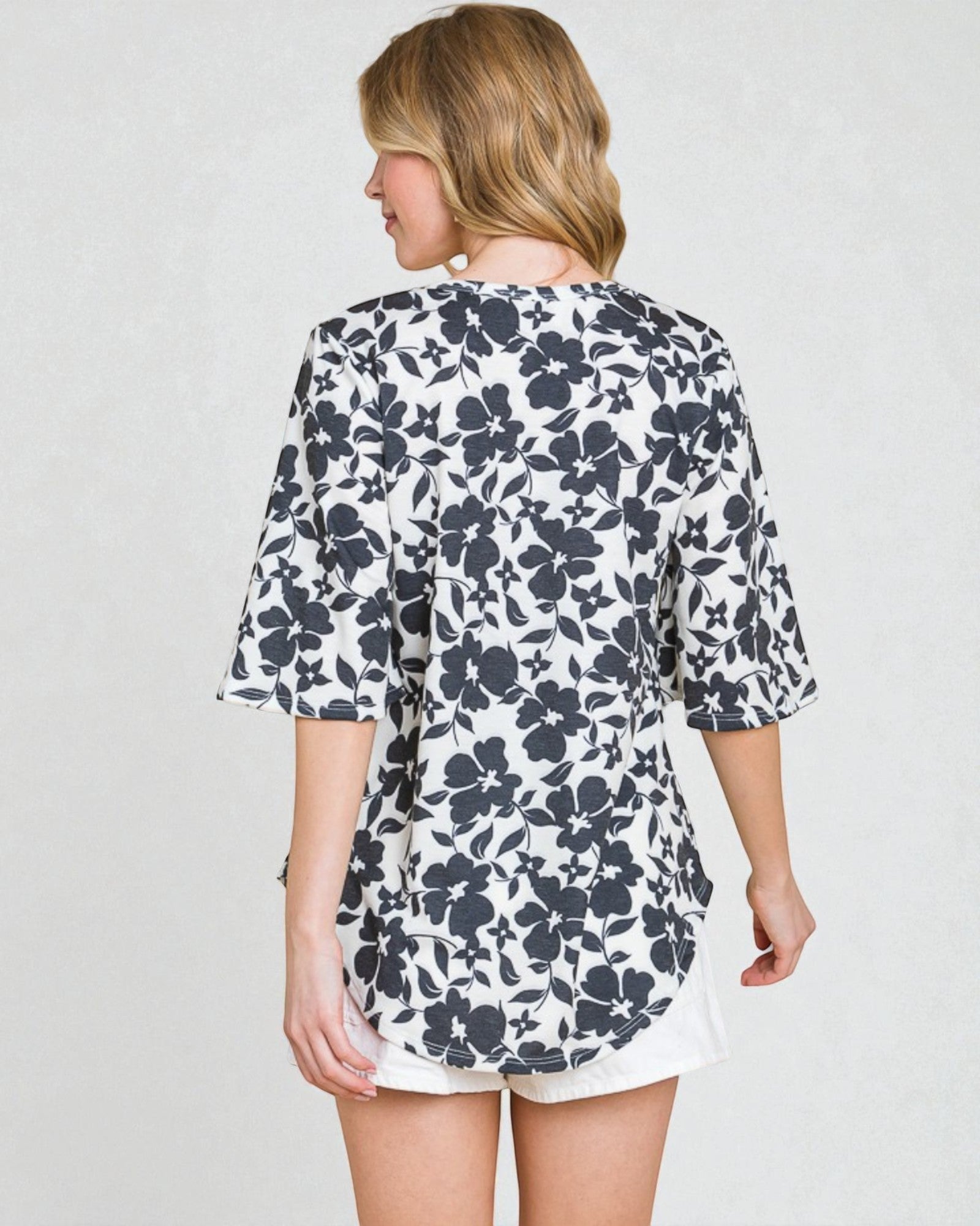 Woman wearing a floral dress with a plain background