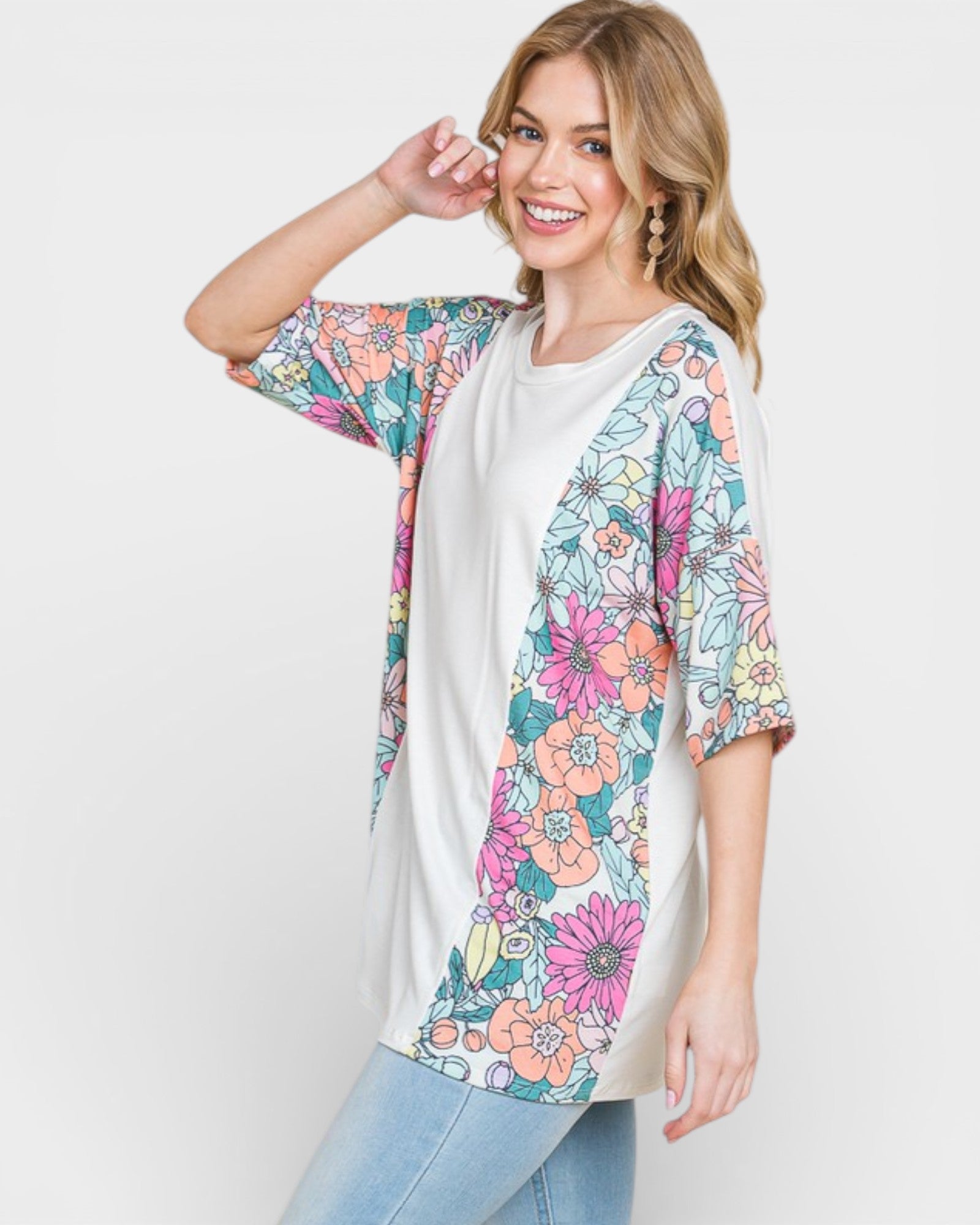 Woman wearing a colorful floral kimono over a white shirt on a light gray background