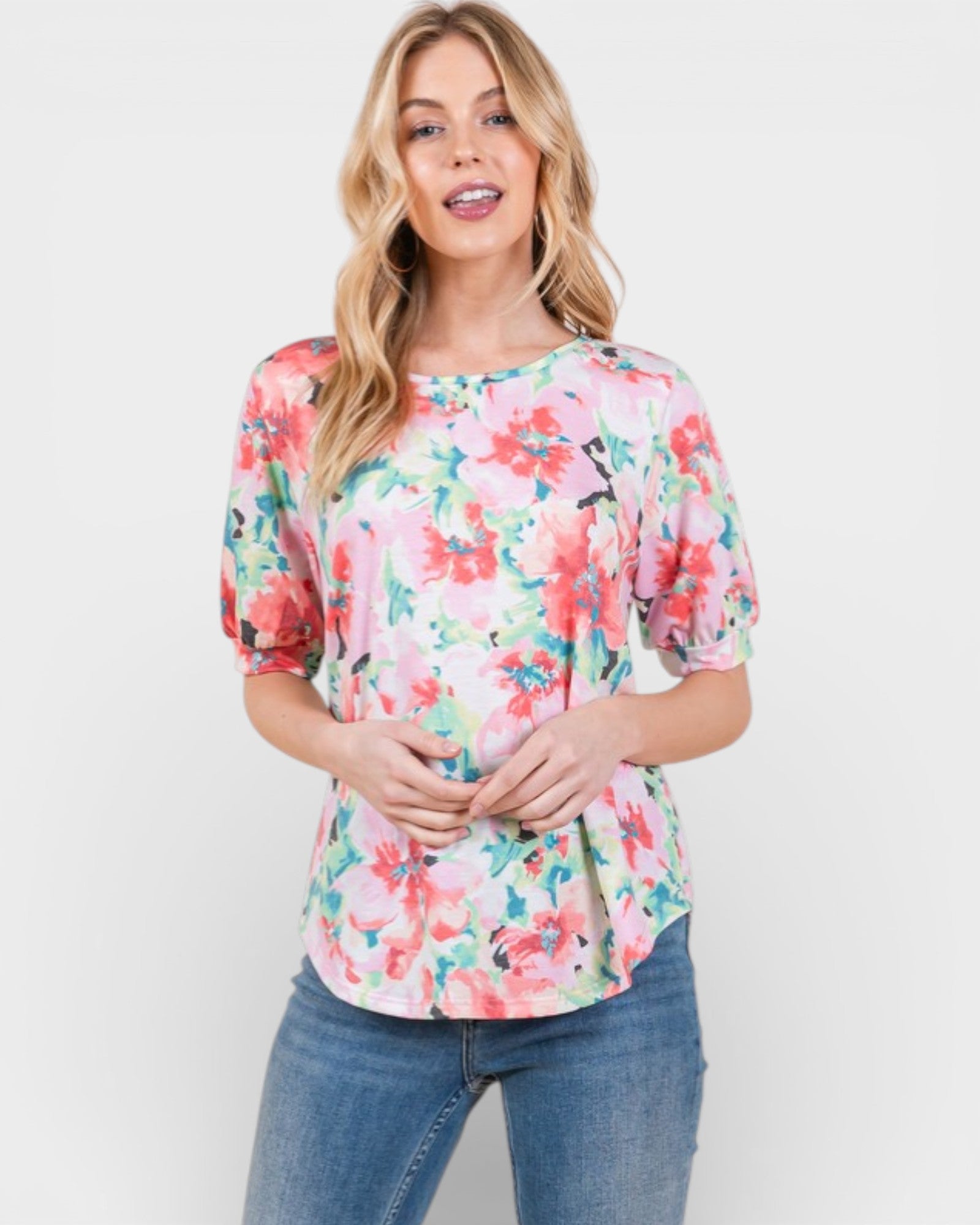 Woman wearing a floral blouse and jeans on a white background