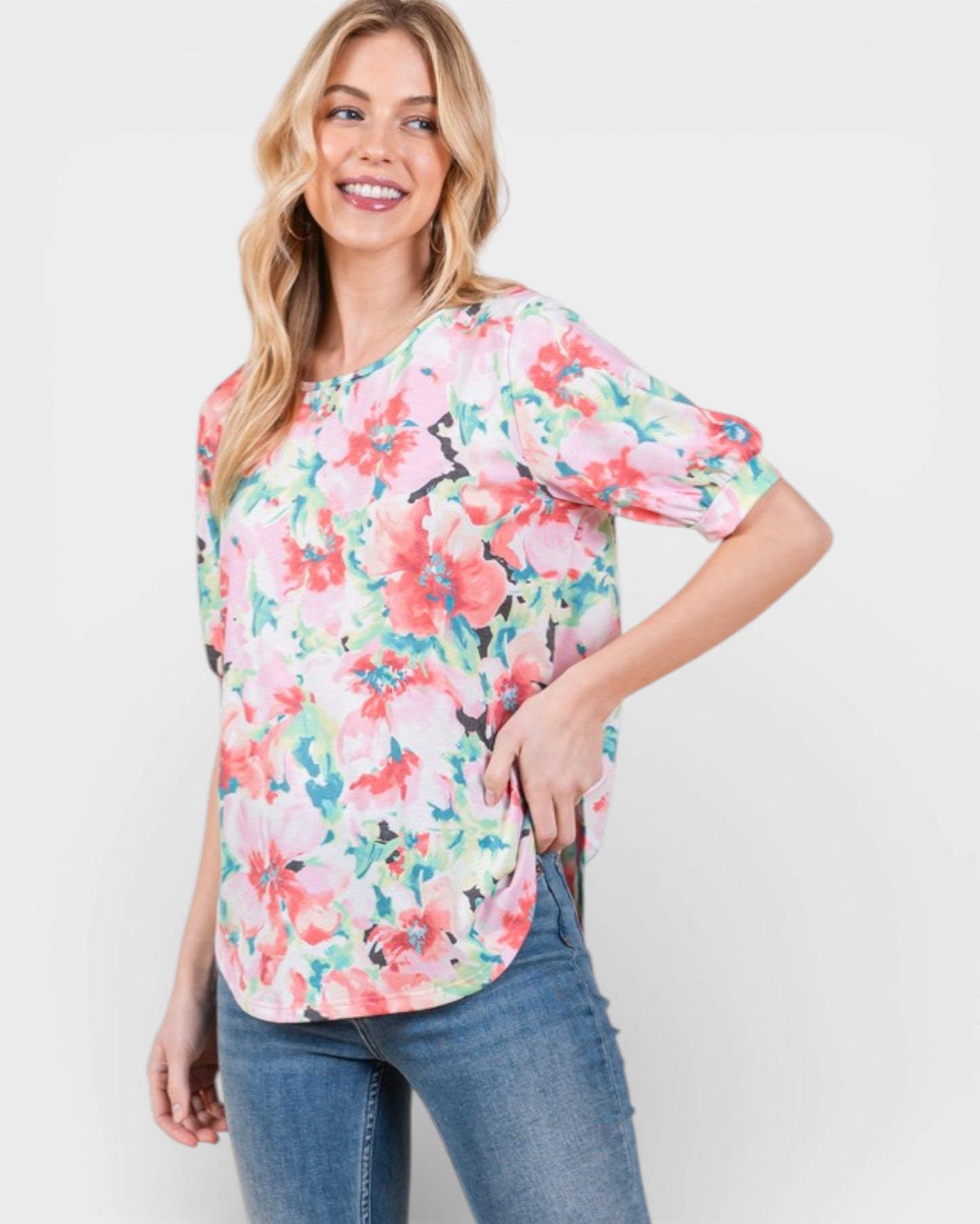 Woman wearing a floral blouse and jeans on a white background