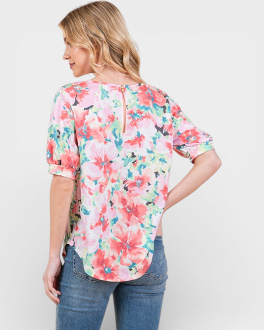 Woman wearing a floral blouse and jeans on a white background