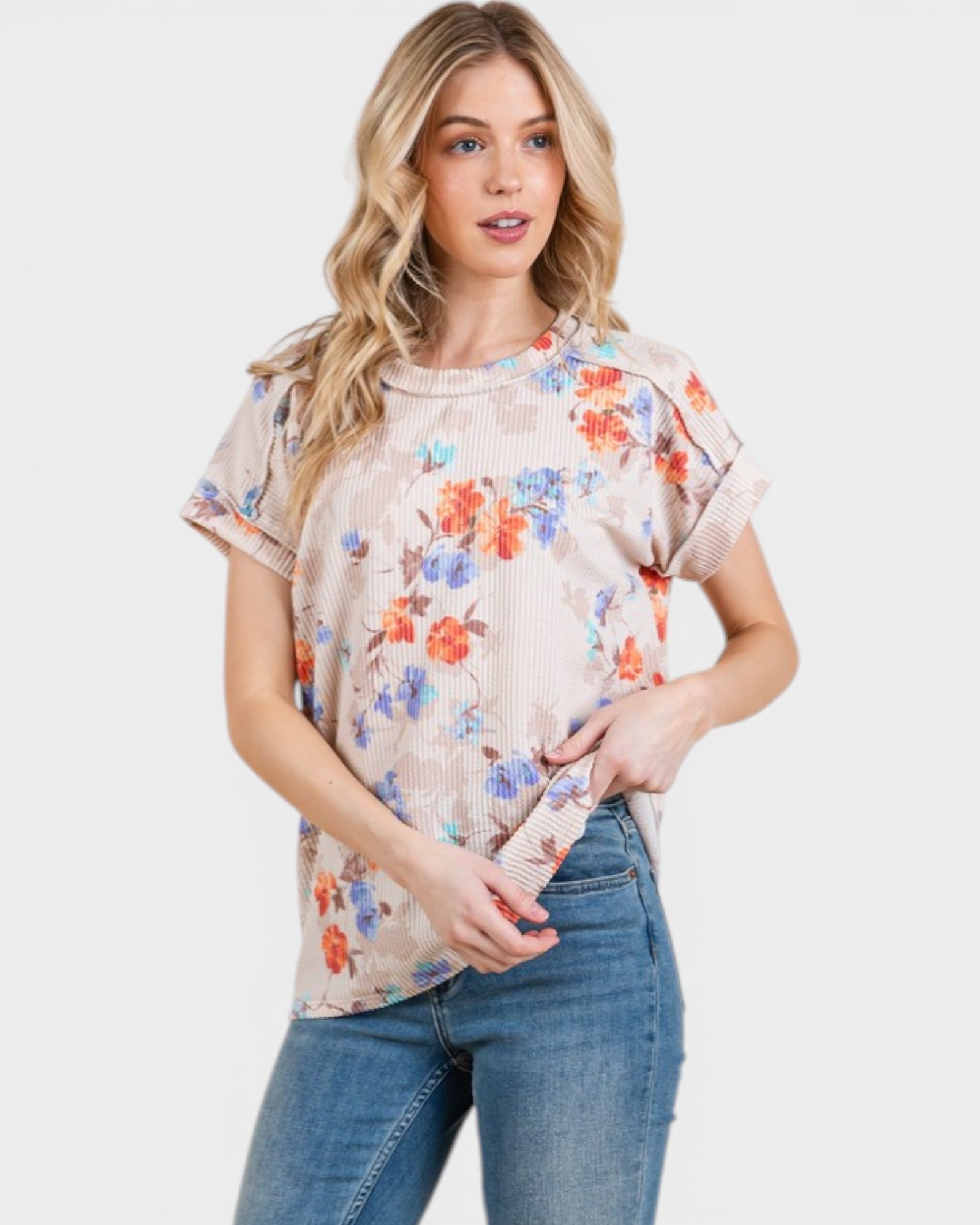 Woman wearing a floral blouse and jeans on a white background