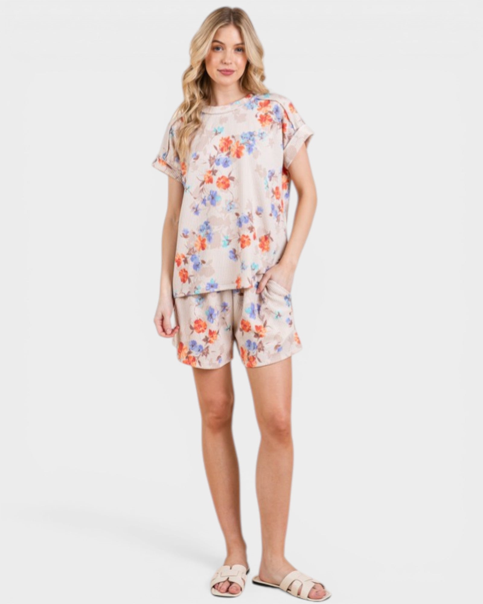 Woman wearing a floral pajama set on a white background