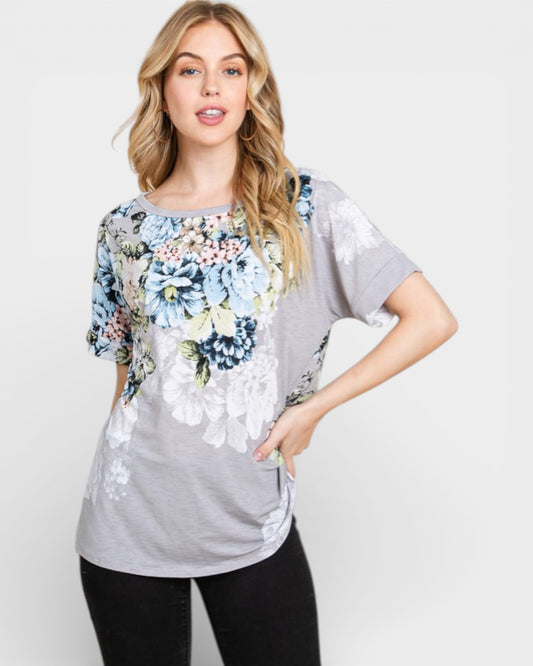 Woman wearing a gray t-shirt with floral designs on a white background
